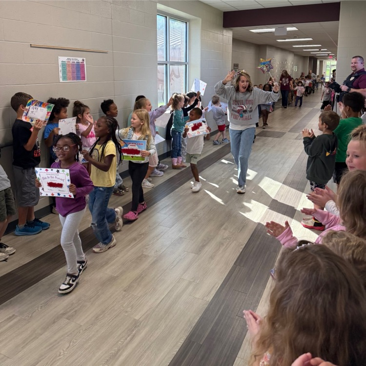 teacher leads students in the hallway