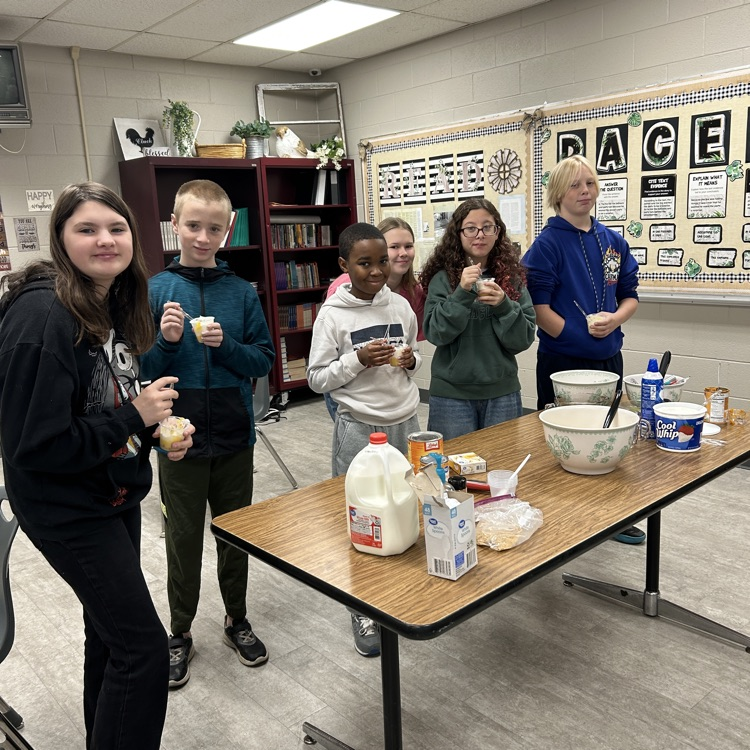 students trying pumpkin in a cup, others smiling
