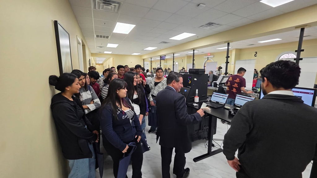 group of students inside the Mexican Consulate, listening to a speech