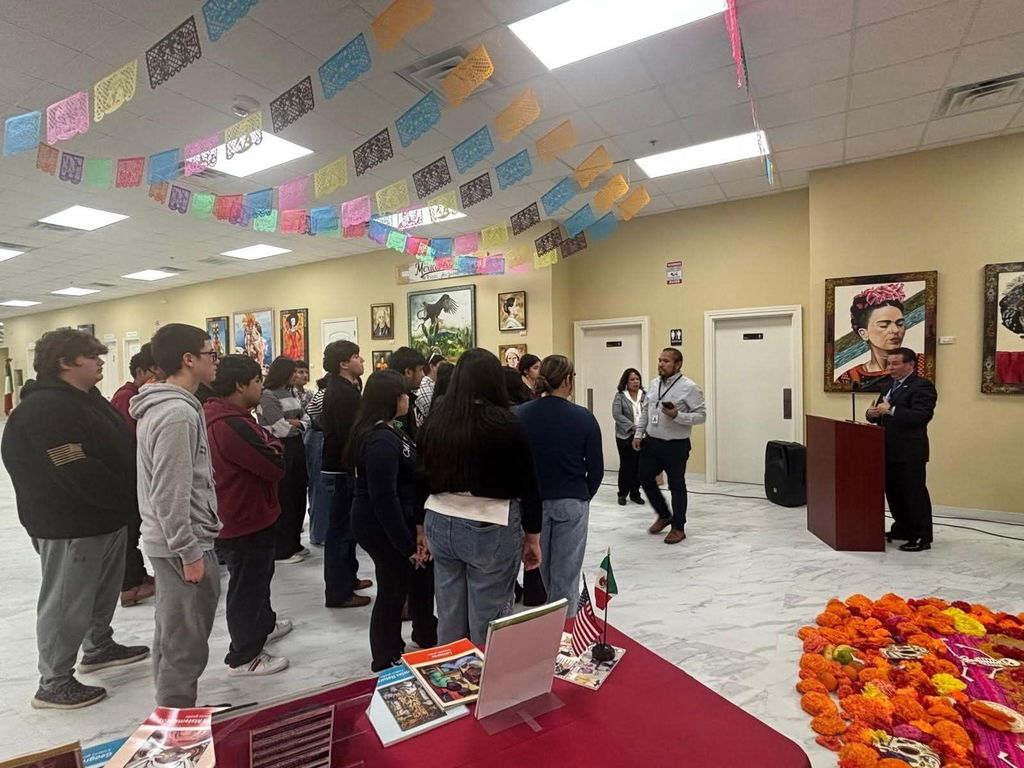 group of students inside the Mexican Consulate, listening to a speech