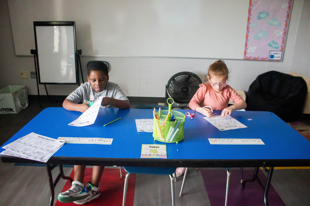 AES students cut out and glue in the missing vowels.