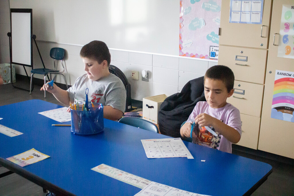AES students cut out and glue in the missing vowels.