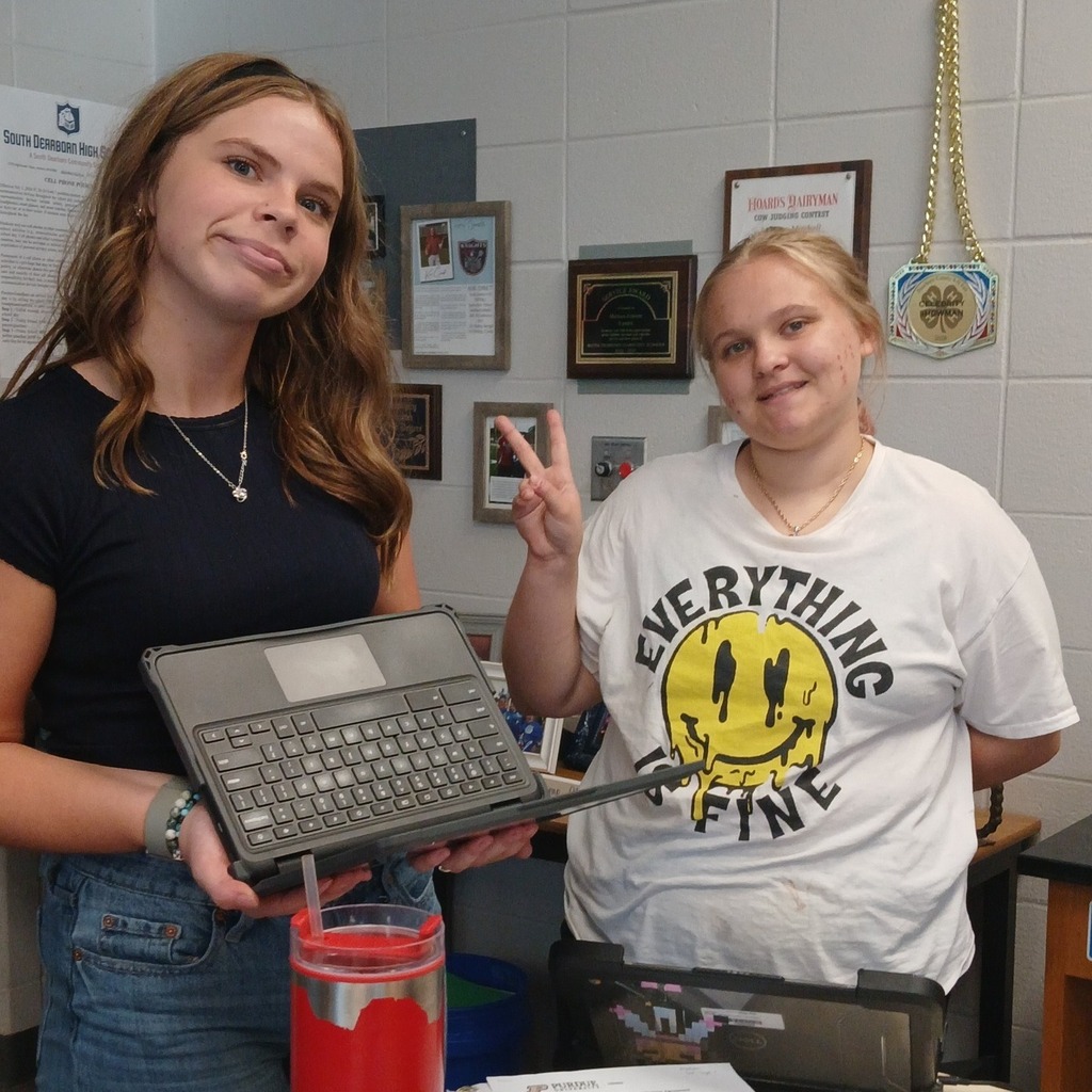 Two South Dearborn High School Animal Science students posing with a laptop in their classroom.
