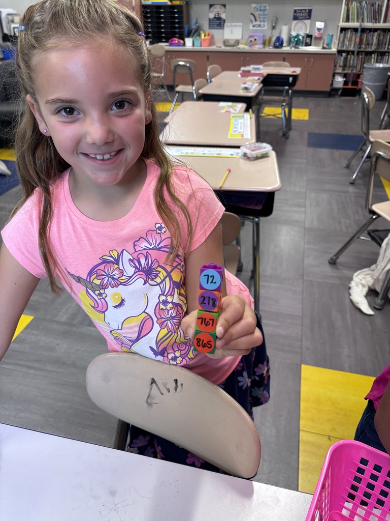 2nd grade student at Dillsboro Elementary School holding a stack of number cubes arranged in order for a place value math activity.