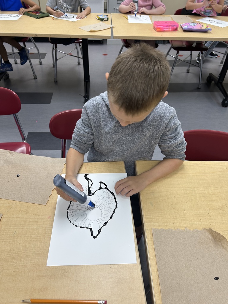 Aurora Elementary student outlining an orchid drawing with black glue during Ms. Friedhoff's South America art unit.