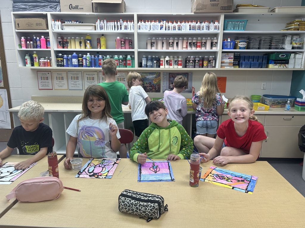 Aurora Elementary students smiling with their colorful abstract orchid paintings in Ms. Friedhoff's art class.