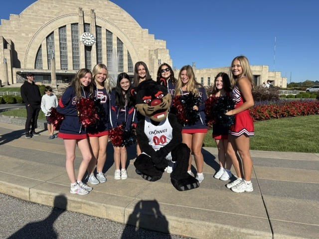 South Dearborn High School cheerleaders smile with the University of Cincinnati Bearcat mascot outside Union Terminal.