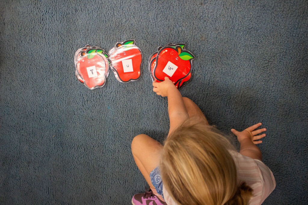 AES kindergarten students hone their literacy skills in apple-themed centers.