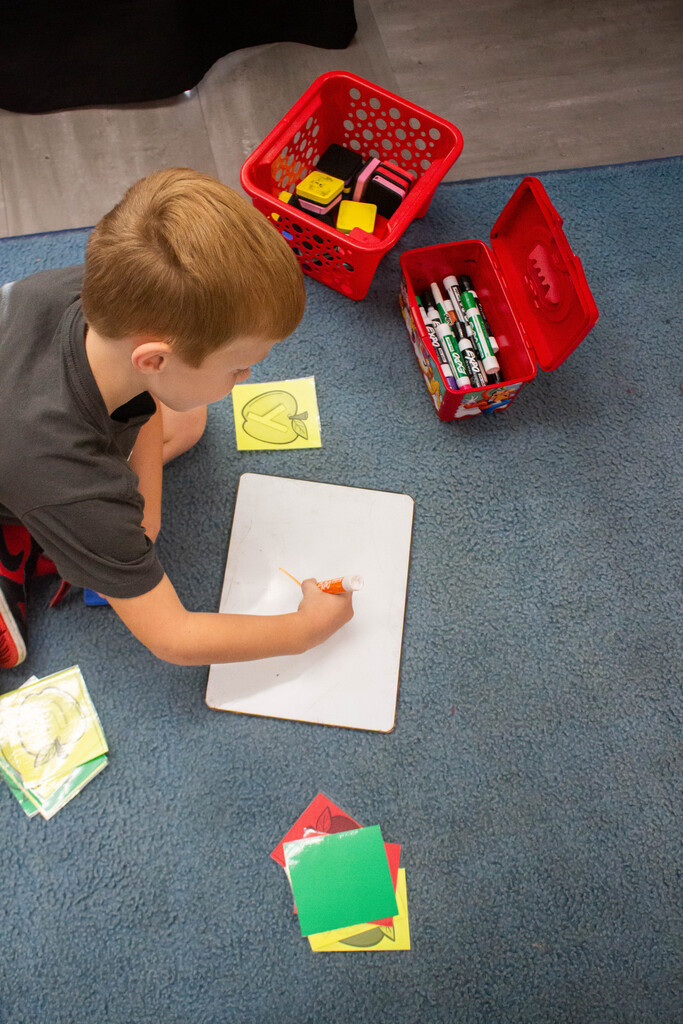 AES kindergarten students hone their literacy skills in apple-themed centers.