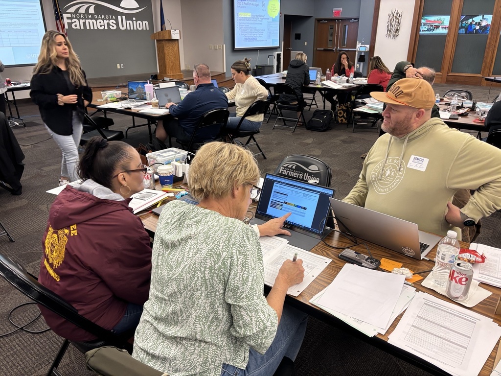 three educators working at a computer and taking notes