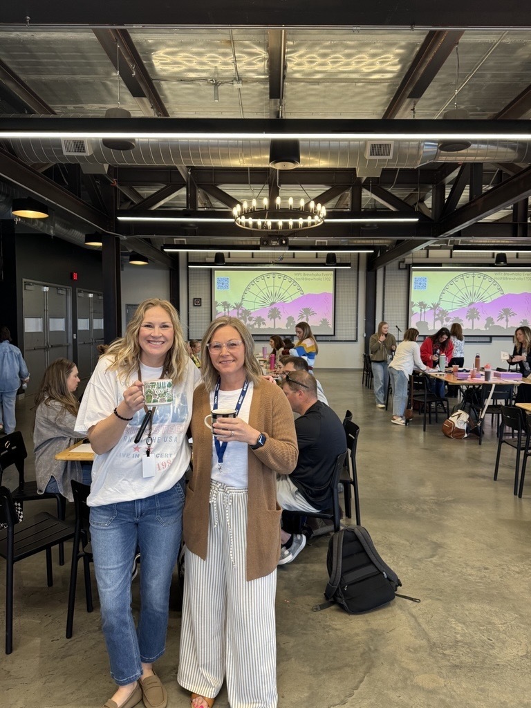 two people smiling with cups of coffee