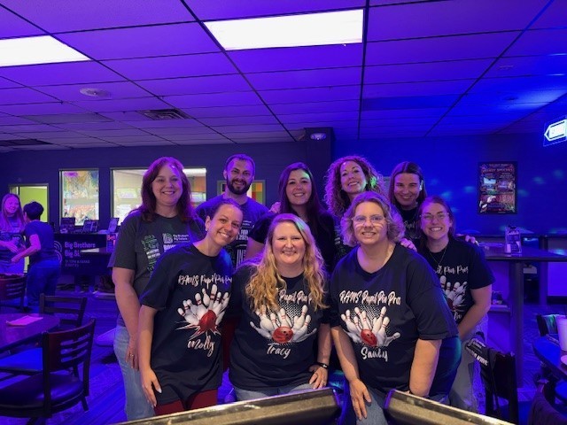 A group of SESD staff posing for a group picture at a bowling alley.