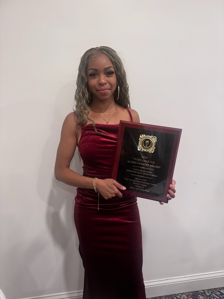 Student posing with her award plaque.