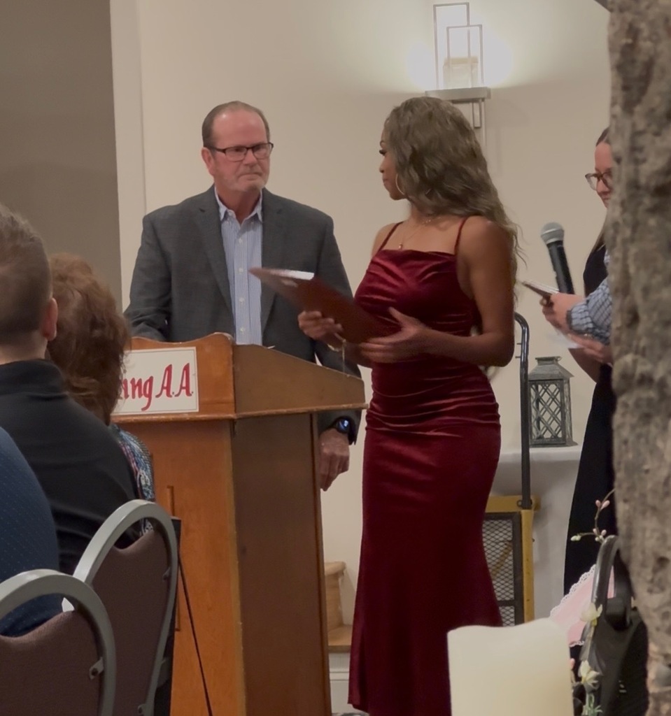 Student being presented an award at a podium.