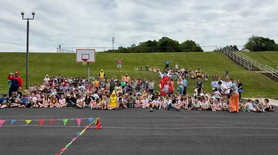 A large crowd of students sitting at the edge of pavement getting ready for a Mario Brothers style race.