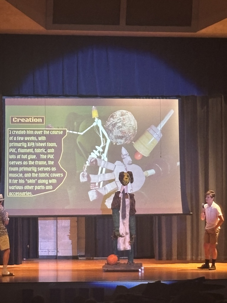 A student on stage demonstrating a creation.