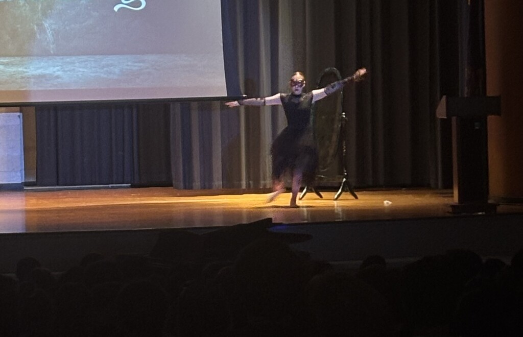 A student on stage doing a solo dance routine.