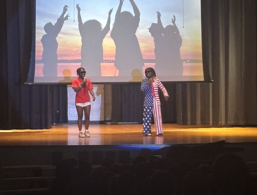 Two students on stage with microphones.