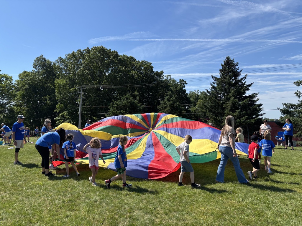 Students holding a large parachute.