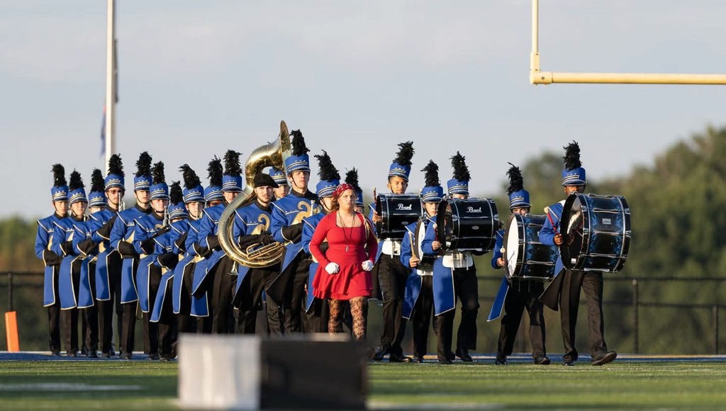 Picture of marching band members entering the field for their performance.