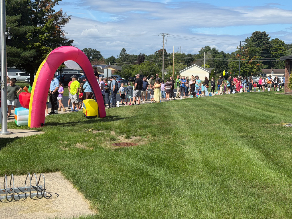 Photo of people standing on a sidewalk.