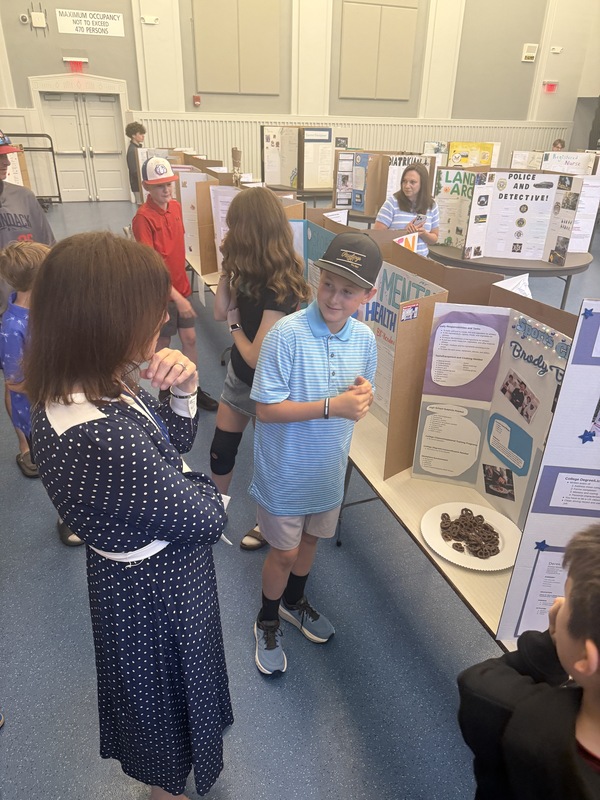 A student shows and adult a project they have created