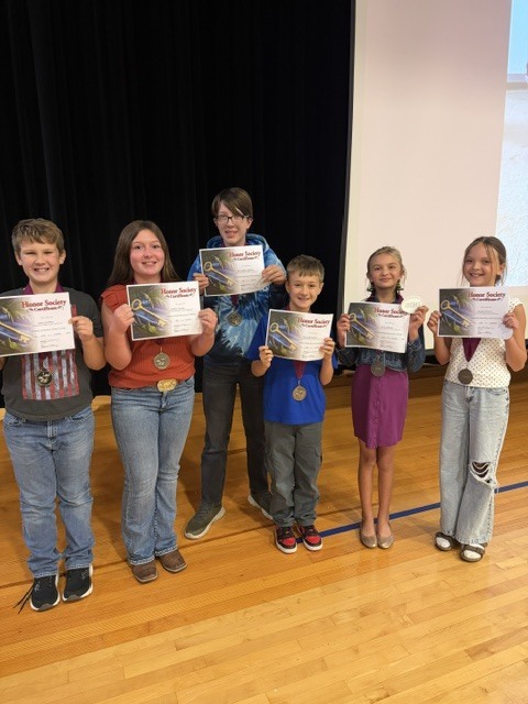 Honors students standing with awards