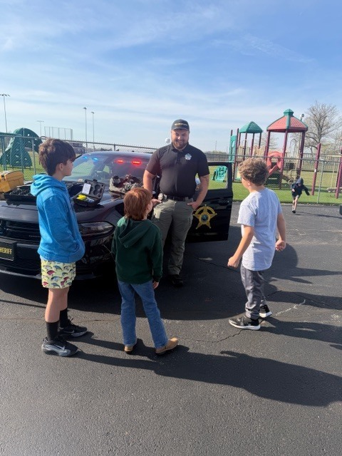 students outside a police car