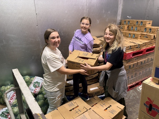 students carrying boxes at food pantry