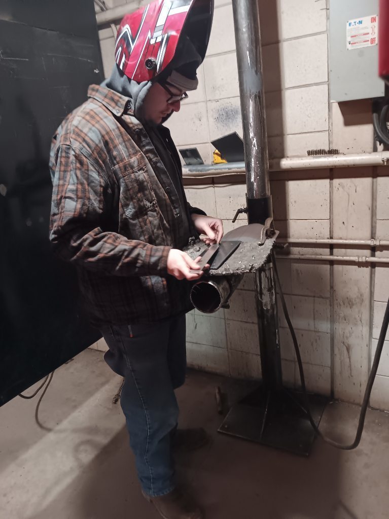 Eyn Quade (Ridgeway) lays out a lap joint for his GMAW project with a combination square