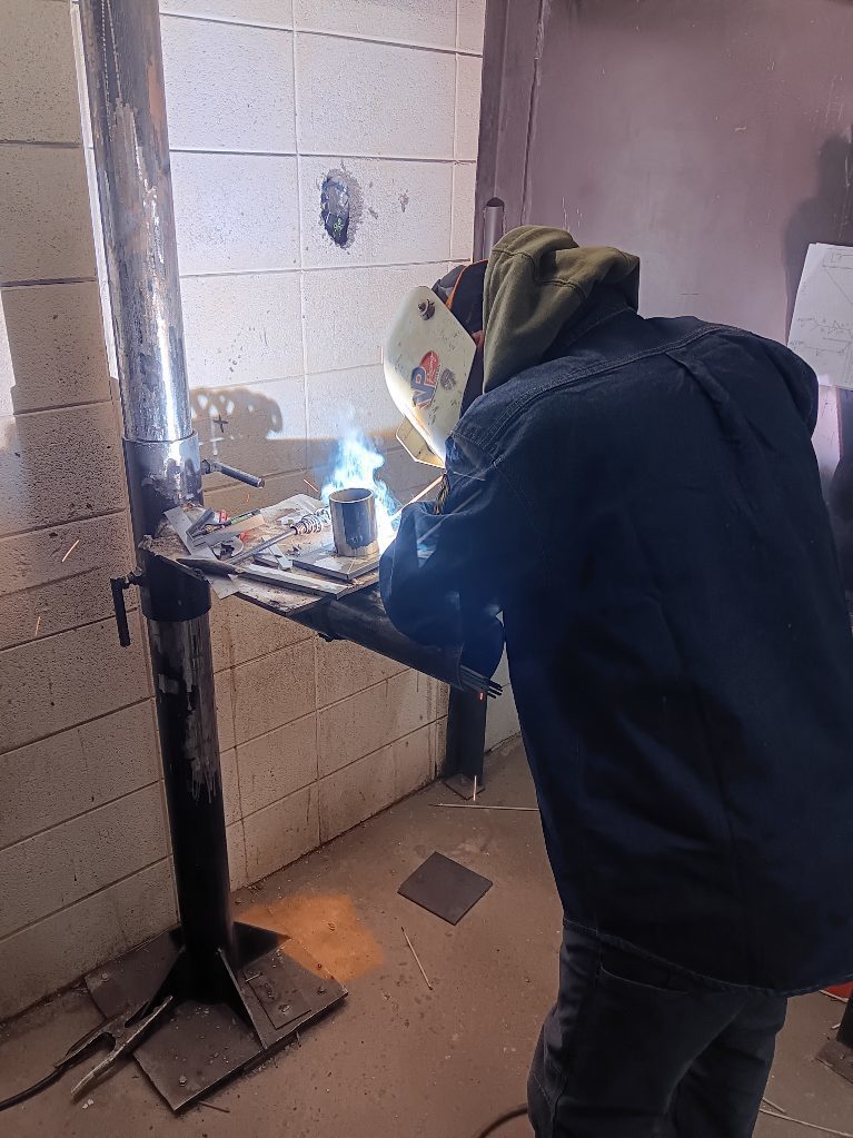 Dustin Hamilton (North Harrison) fires up with some E7018 on his pipe to plate joint