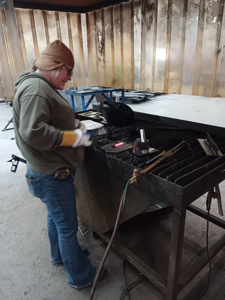 Samantha Berry (South Harrison) taps her 2"X4" cutout loose from her OFC project