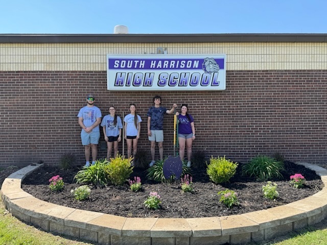 Group photo of South Harrison National Honor Society students standing in the flower bed in front of the high school. From left to right: Ruger Johnson, Addison Polley, Abby Owens, Brody Templeton, and Emily Burnett.