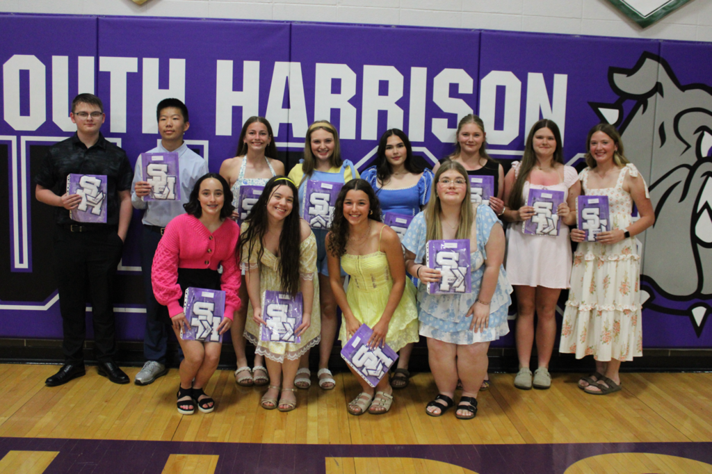 Freshman students posing together, holding their academic certificates and academic letters in recognition of their accomplishments.