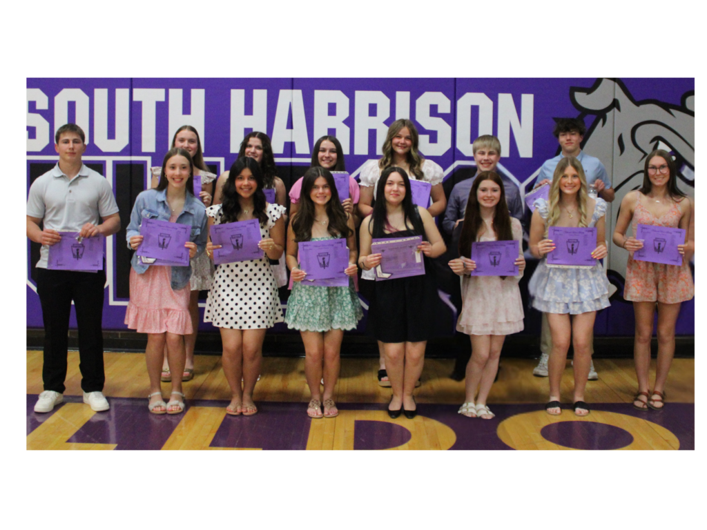 Newly inducted National Honor Society members standing together as a group, smiling and dressed in formal attire during the induction ceremony, celebrating their achievement in scholarship, leadership, service, and character.