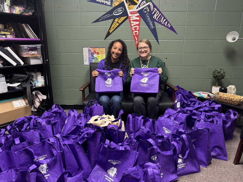 Mrs. Hagan and Mrs. McConkey pose with purple BTC bags filled with goodies for teachers.