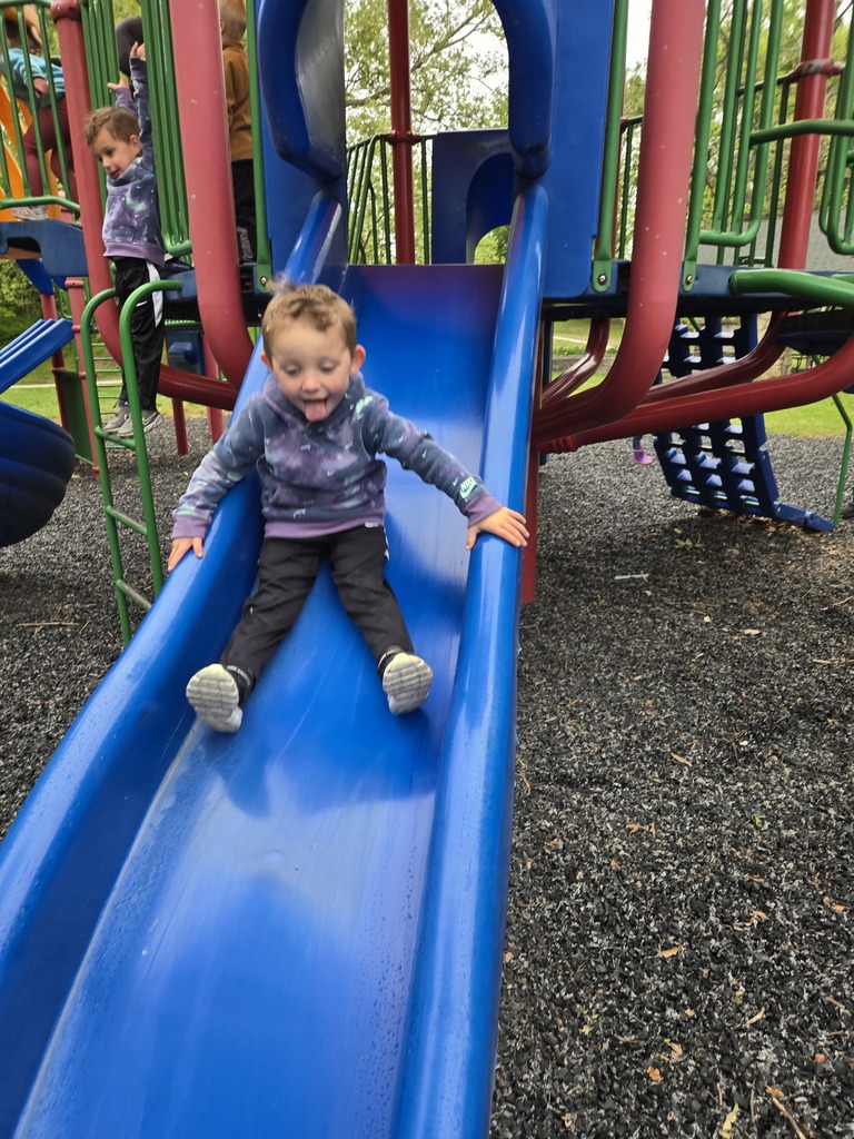 Preschool students from Miss Emily’s class playing outside together during end-of-year activities, enjoying outdoor games, running, and smiling in a park or playground setting.