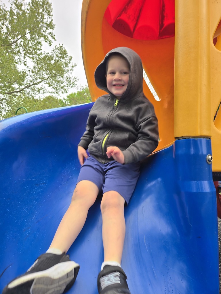 Preschool students from Miss Emily’s class playing outside together during end-of-year activities, enjoying outdoor games, running, and smiling in a park or playground setting.