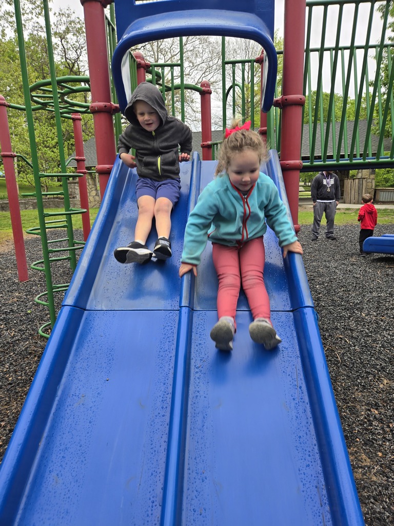 Preschool students from Miss Emily’s class playing outside together during end-of-year activities, enjoying outdoor games, running, and smiling in a park or playground setting.