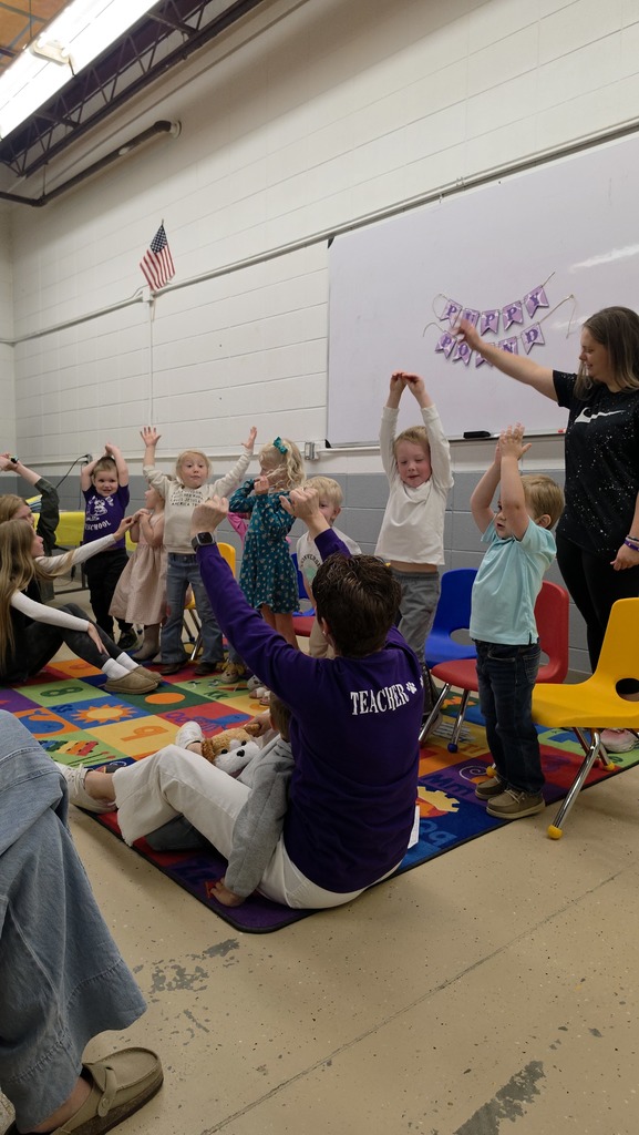 Preschool students participating in classroom learning activities with classmates and teachers.