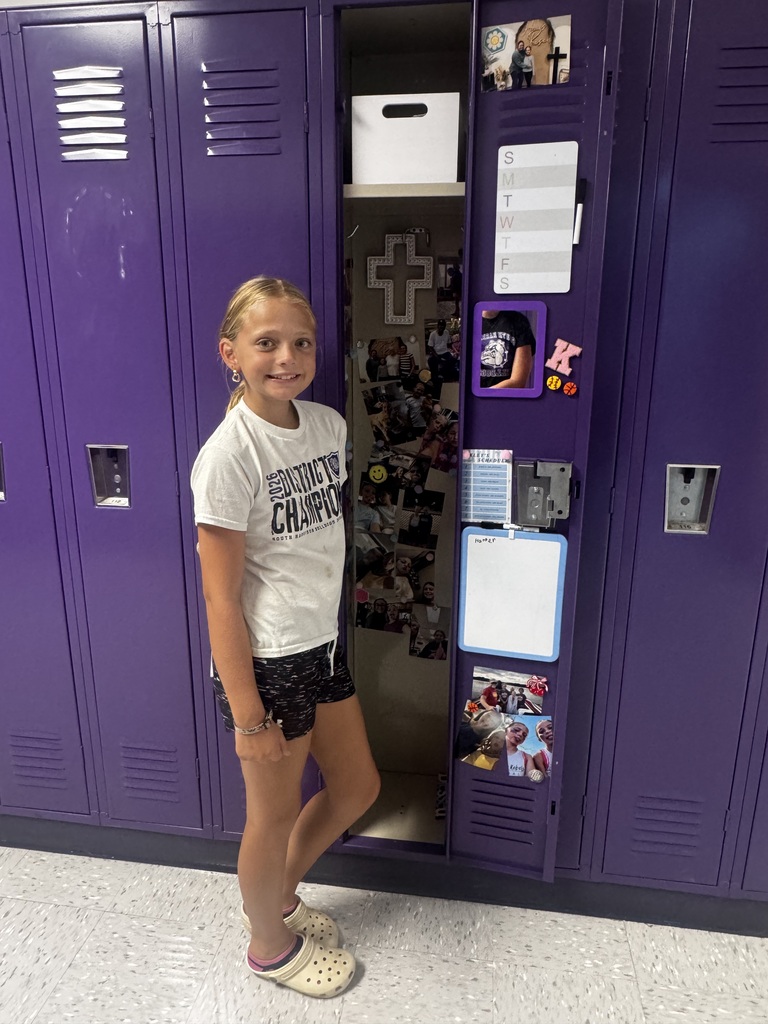 A 5th grader proudly shows off a decorated locker during orientation.