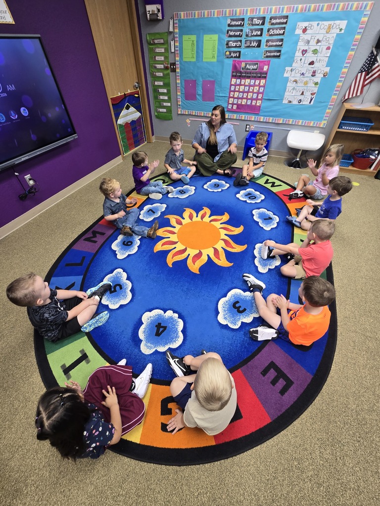 Group of kids on the rug having circle time together.