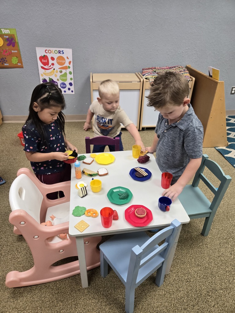 Kids using imagination with play food and pretending to have lunch together.
