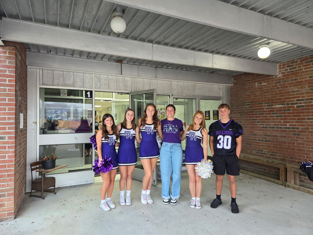 Members of the South Harrison Cheer Team, Softball Team, and Football Team pose for a picture in front of the elementary school.