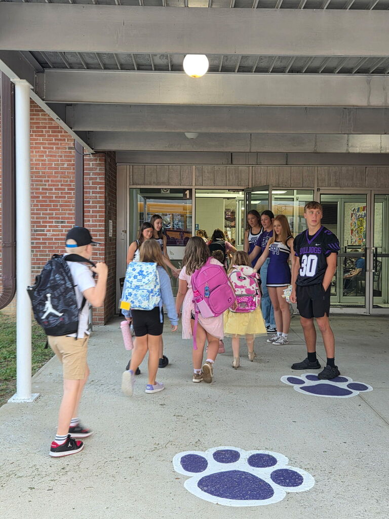 High School Athletes greet elementary Students with High Fives as they enter school on Friday Morning