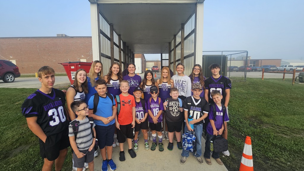 A group of high school athletes pose with some elementary students. We love Bulldog Fridays!