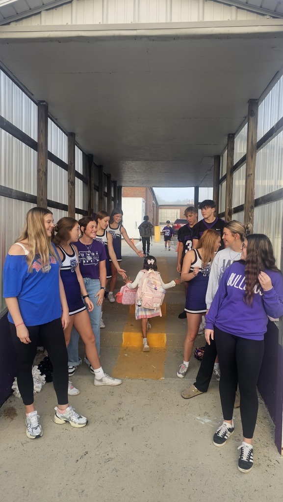 High School Athletes line the stairs at the car rider drop off and greet elementary students with High Fives