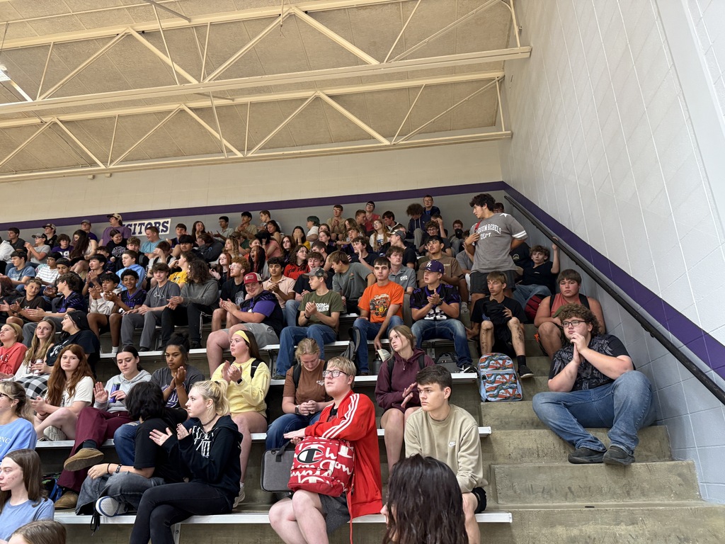 Students seated together in the stands listening attentively during a suicide awareness assembly.