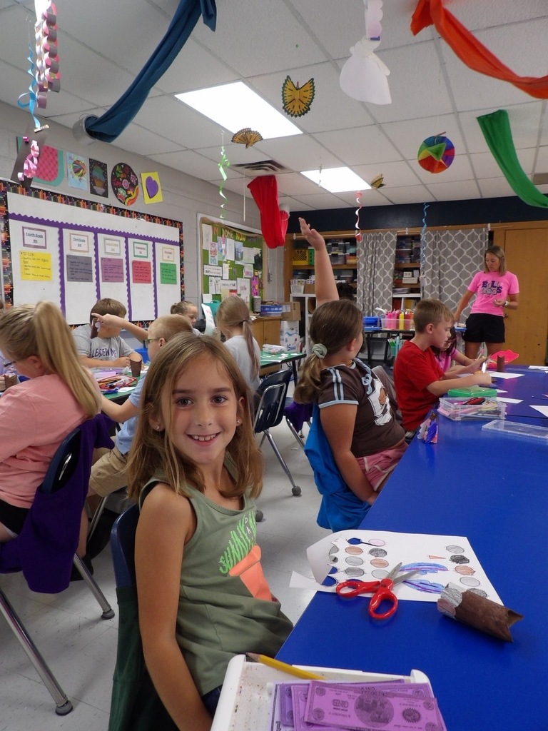 Elementary student posed with crafted owl made in art class.
