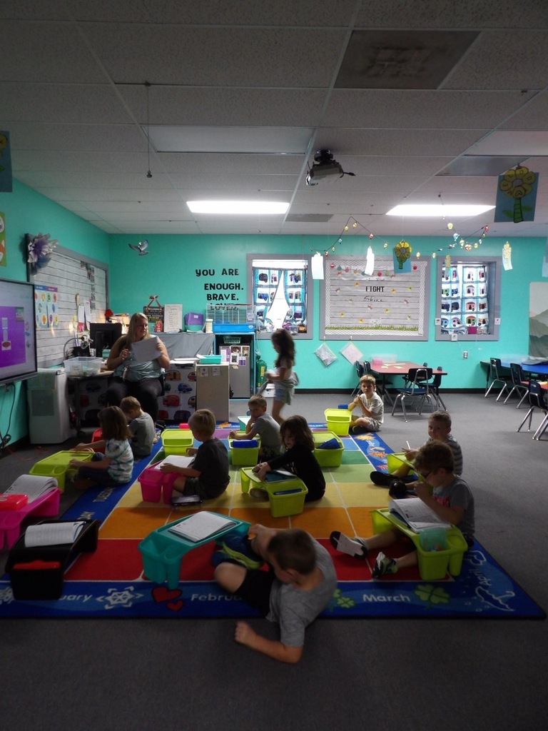 Kindergarden students working on writing letters in class.